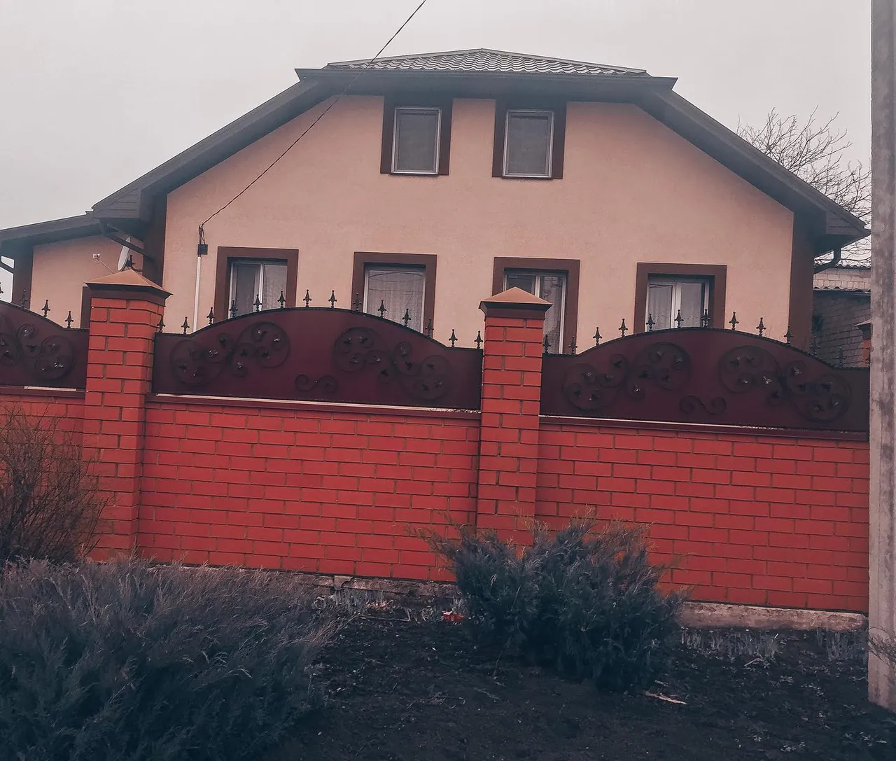 Розовый дом за красной оградой